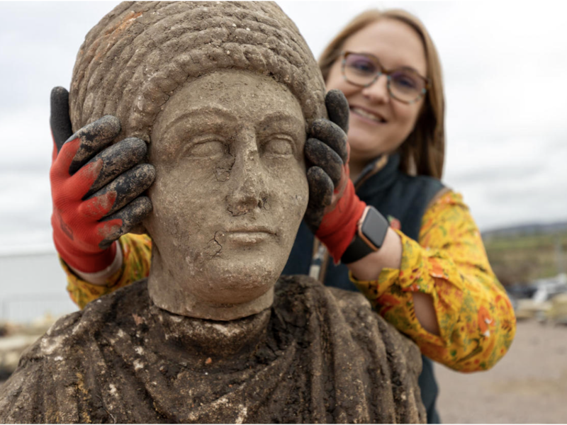Woman placing a head on a statue